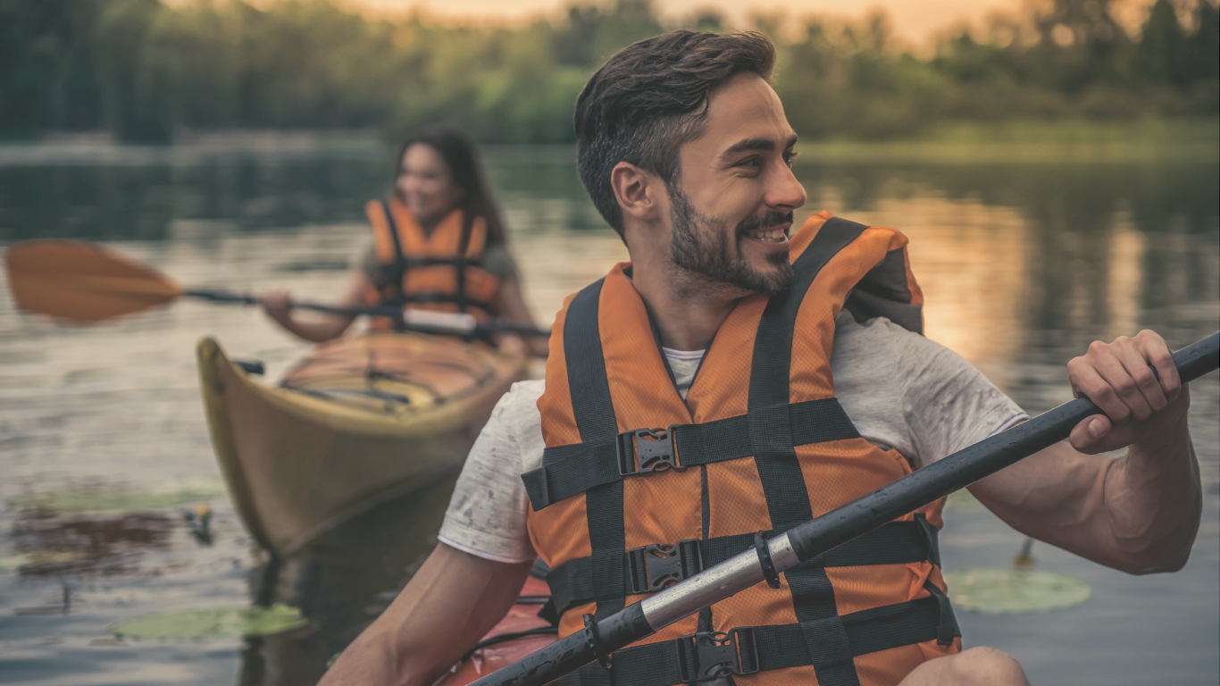 A couple kayaking during a casual RV camping trip, enjoying the outdoors and scenic waterways.